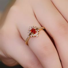 a woman's hand with a red and white diamond ring