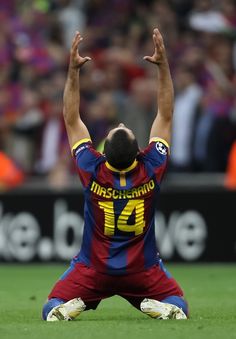 a soccer player sitting on the ground with his hands in the air