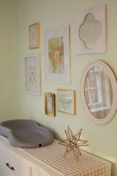 a white dresser topped with lots of framed pictures