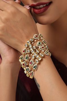 Express your love for pearls and florals with this chic bracelet. A timeless kundan bracelet set on a silver alloy base and embellished with a beautiful assembly of shell pearls, set on a 22k gold plated floral design. Bracelet - Adjustable Style Tip - When it comes to getting a classic look, nothing can be better than pearls and kundan. This bracelet is fit for a woman who is fiercely independent yet rooted in traditional and cultural heritage, carving her own style with classic and timeless fa Luxury Kundan Chandbalis In Fusion Style, Luxury Gold Kundan Bracelets, Elegant Hand-set Pearl Bracelet For Festivals, Elegant Hand Set Pearl Bracelet For Festive Occasions, Elegant Hand-set Pearl Bracelet For Festive Occasions, Kundan Jeweled Bracelets For Celebration, Kundan Bracelets For Celebration, Elegant Kundan Bracelets For Festivals, Elegant Meenakari Bracelets For Celebrations