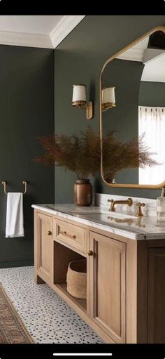 a bathroom with green walls and wooden cabinets