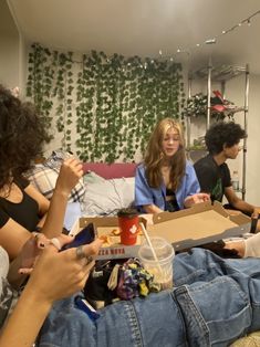 four people sitting on a couch eating and drinking