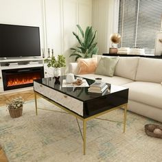 a living room with a couch, coffee table and fireplace in the corner on carpeted floor