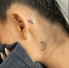 a woman with a small tattoo behind her ear