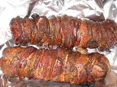 two pieces of meat sitting on top of aluminum foil