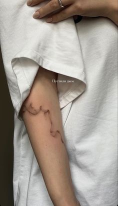 a woman's arm with a small tattoo on it