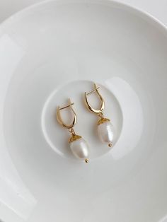 Beautiful Bridal earrings with natural freshwater large pearls and stainless steel earring hooks in Gold color. Length - 3 cm ( 1.2 inch), width - 1 cm (0.5 inch). Please note: your parcel will be shipped from Latvia (EUROPEAN UNION). Parcels within European Union, Switzerland and Norway will be shipped via UPS STANDARD delivery service, please add your mobile phone number at the checkout! Delivery time 3-7 business days.  Parcels to United States, Canada, Australia will be shipped via Standard International Airmail and it takes 2-5 weeks to receive your parcel. For fast delivery, please choose UPS EXPRESS DELIVERY worldwide! AVERAGE shipping times: to European Union, Norway, Switzerland via UPS Standard delivery - 3-7 business days, to USA, Canada, Australia via Standard Airmail - 2-5 wee Classic Teardrop Baroque Pearl Earrings, Pearl White Drop Earrings With Pearl Pendant, Minimalist Pearl White Teardrop Earrings, Minimalist Teardrop Pearl White Earrings, Minimalist Drop Hoop Earrings For Wedding, Oval Pearl Drop Earrings In Pearl White, Baroque Pearl Drop Teardrop Earrings, Teardrop Baroque Pearl Drop Earrings, Classic Gold Teardrop Earrings With Pearl Charm