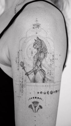 the back of a woman's shoulder with an egyptian tattoo design on her arm