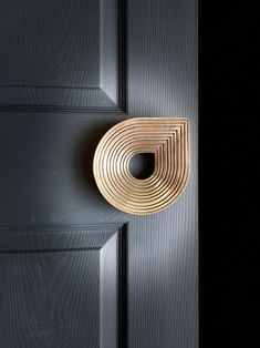 a door handle on the side of a wooden door with black woodgrain and silver paint