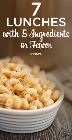 a white bowl filled with macaroni and cheese on top of a wooden table