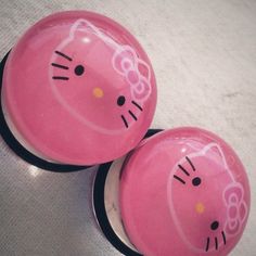 two pink hello kitty knobs sitting on top of each other