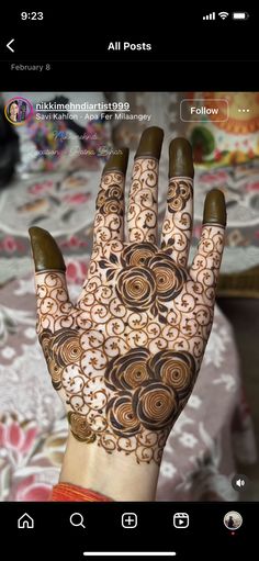 the hand is decorated with henna on it and has an intricate design in brown