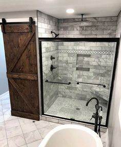 a bathroom with a tub, shower and sliding glass door