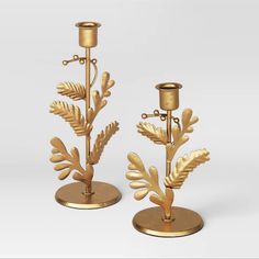 two golden candlesticks with leaves on them