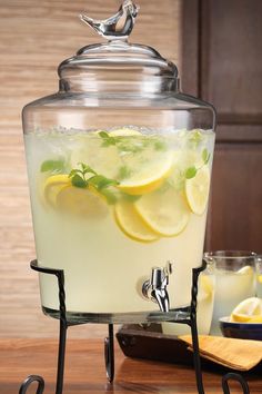 a glass pitcher filled with lemonade and ice