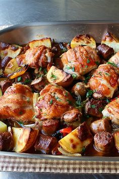 a pan filled with potatoes and meat on top of a table