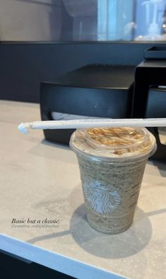 a starbucks drink with a straw sticking out of it's top sitting on a counter