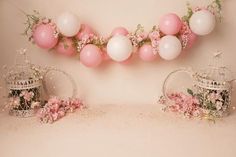 pink and white balloons are hanging from the wall above two tea kettles with flowers on them