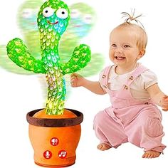 a baby sitting next to a cactus plant