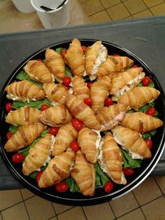 croissants with tomatoes, lettuce and chicken on a black plate