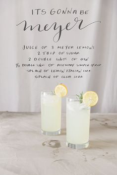 two glasses filled with lemonade sitting next to each other on top of a table