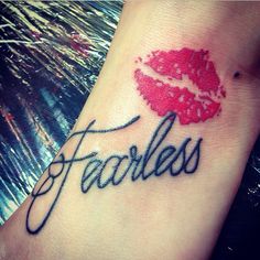 a tattoo with the word fearless written on it's wrist and red lipstick imprint