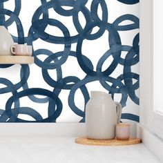 the wallpaper in this kitchen is painted blue and has circles on it, as well as two vases