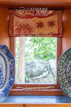 three plates sitting on top of a window sill in front of a wooden frame