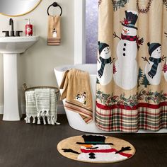 a bathroom with a snowman shower curtain and rug