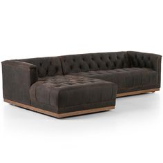 a large sectional sofa with an ottoman and footstool in brown leather, on a white background