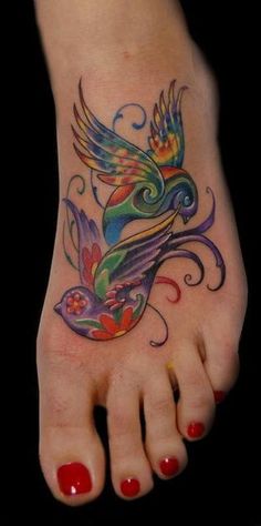 a foot with a bird tattoo on it