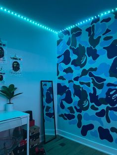 a room with blue camouflage wallpaper and lights on the ceiling, along with a plant