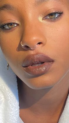 a close up of a woman with makeup on her face and towel around her neck