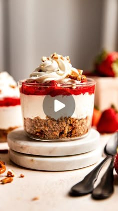 two desserts with strawberries and whipped cream on top are sitting on a table