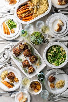 a table full of food with plates and utensils on it, including carrots