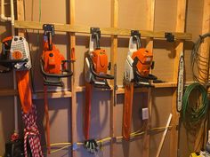 several chainsaws are hanging up on the wall