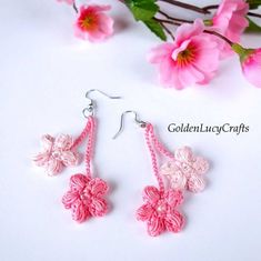 pink crochet flower earrings on white background with pink flowers in the foreground