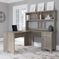 a computer desk with a laptop on it in front of a bookcase and clock