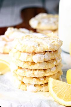 lemon crinkle cookies stacked on top of each other next to a glass of milk