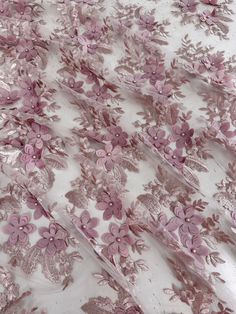 pink flowers on white sheer fabric with metallic foiled edges and sequins in the center