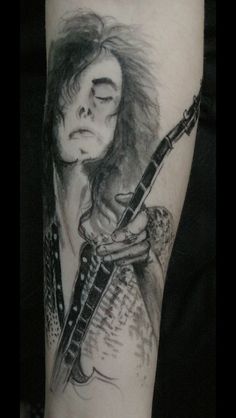 a person with a guitar tattoo on their arm