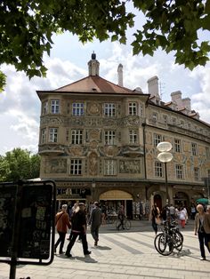 people walking around in front of an old building