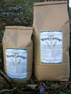 two bags of worm castings sitting next to a tree