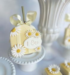 a white vase filled with flowers next to small cakes