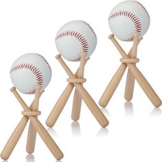 three baseballs are on top of wooden sticks with one ball in the middle and another behind it