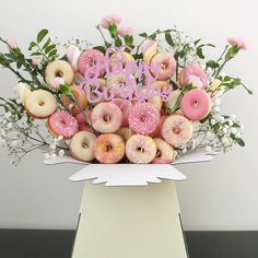 a bouquet of doughnuts and flowers in a box