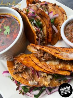 a plate with some tacos and salsa on the side, along with other food items