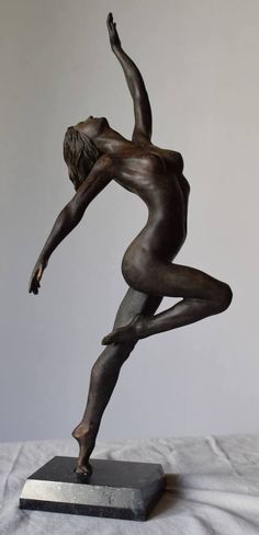 a bronze statue of a woman doing yoga