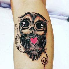 an owl tattoo with a heart on its leg