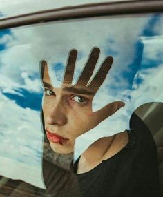 a woman's hand is reflected in the rear window of a car